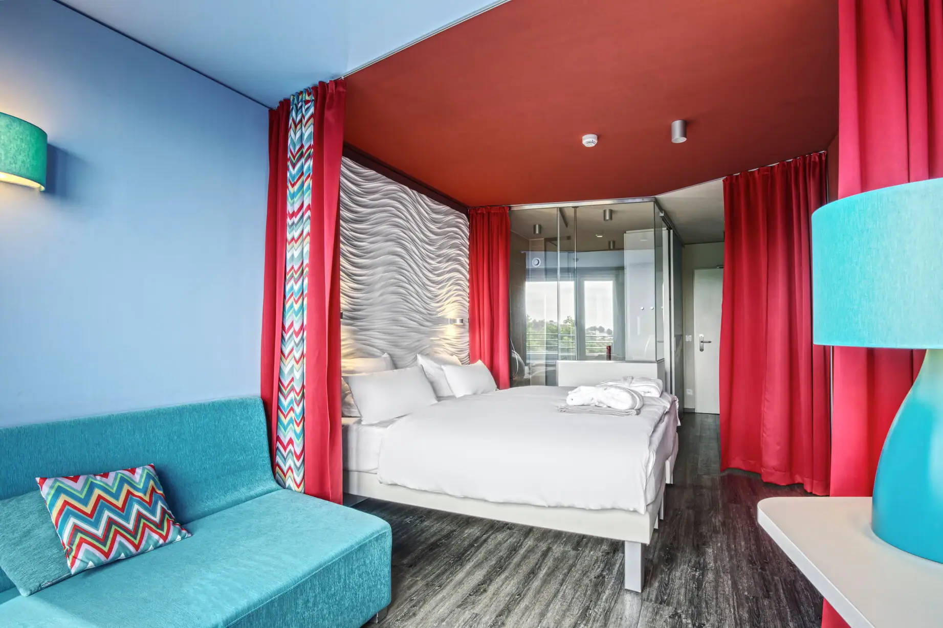 Een kamer met een bed en een blauwe bank.