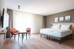Mindervalide kamer Een kamer met een bed en stoelen.