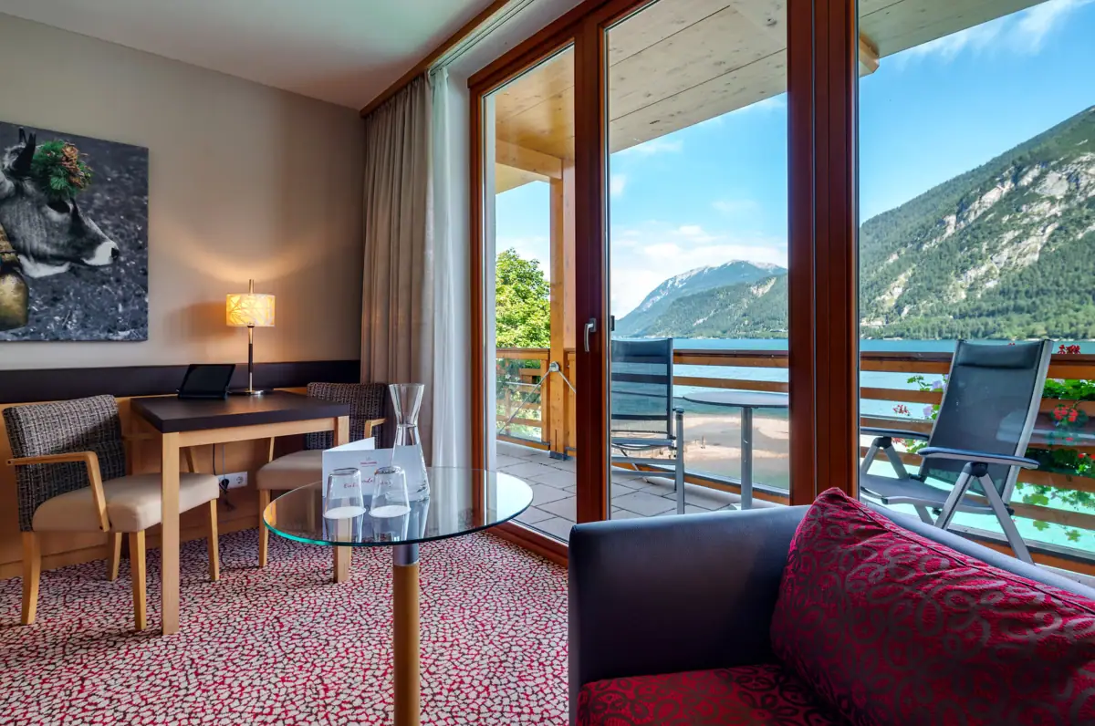 Een kamer met een glazen tafel en stoelen.