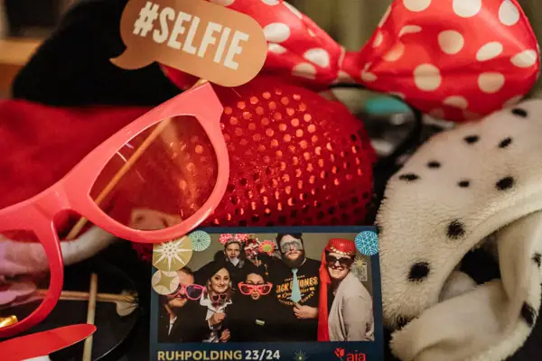 Accessoires voor een fotodoos op een tafel en een foto in het midden met feestvierende mensen.