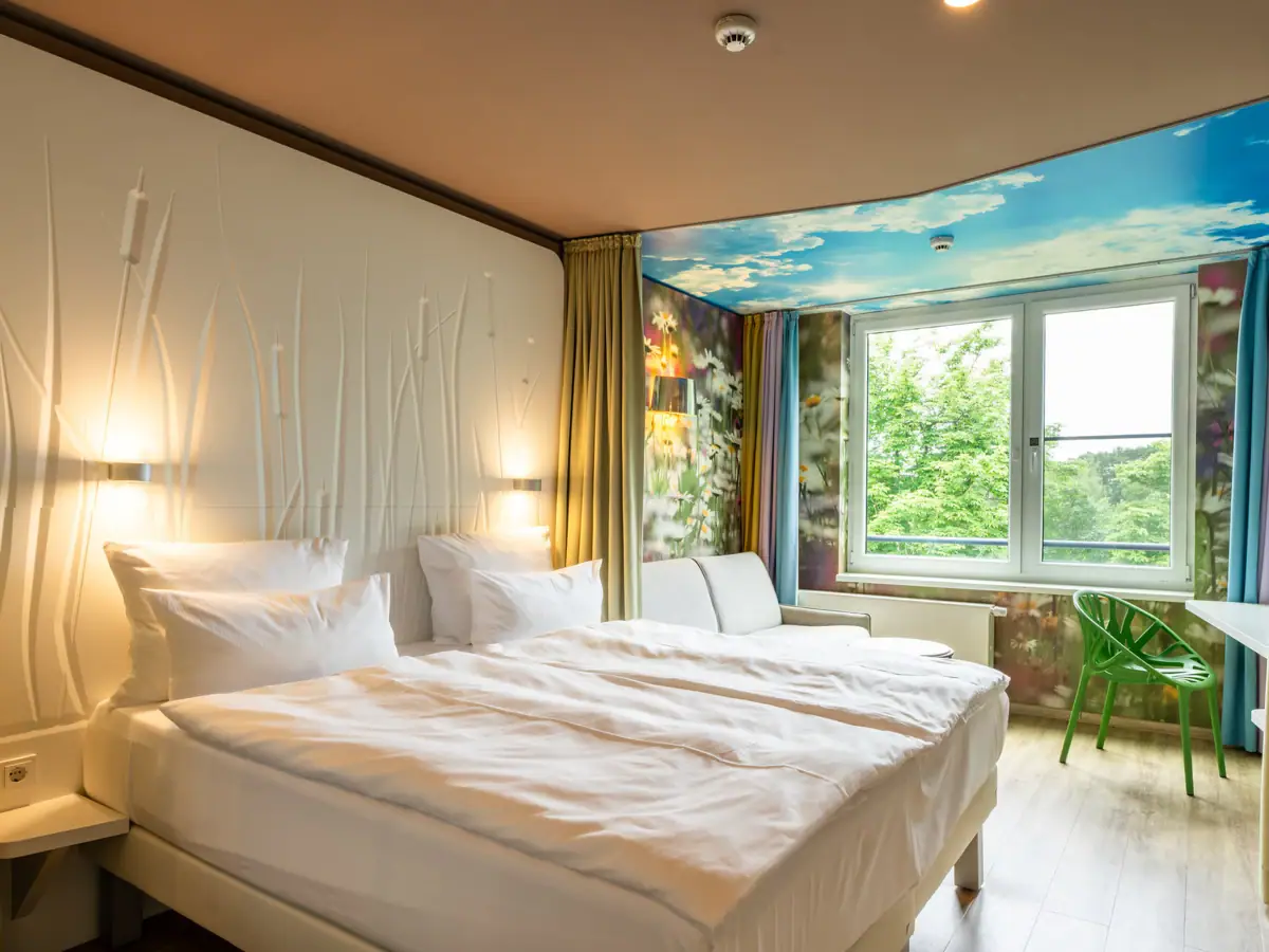 Een kamer met twee bedden en een raam.