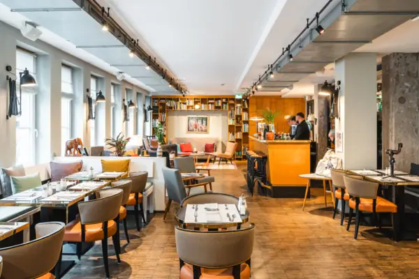 Lobby HENRI Hamburg Een restaurant met tafels en stoelen.