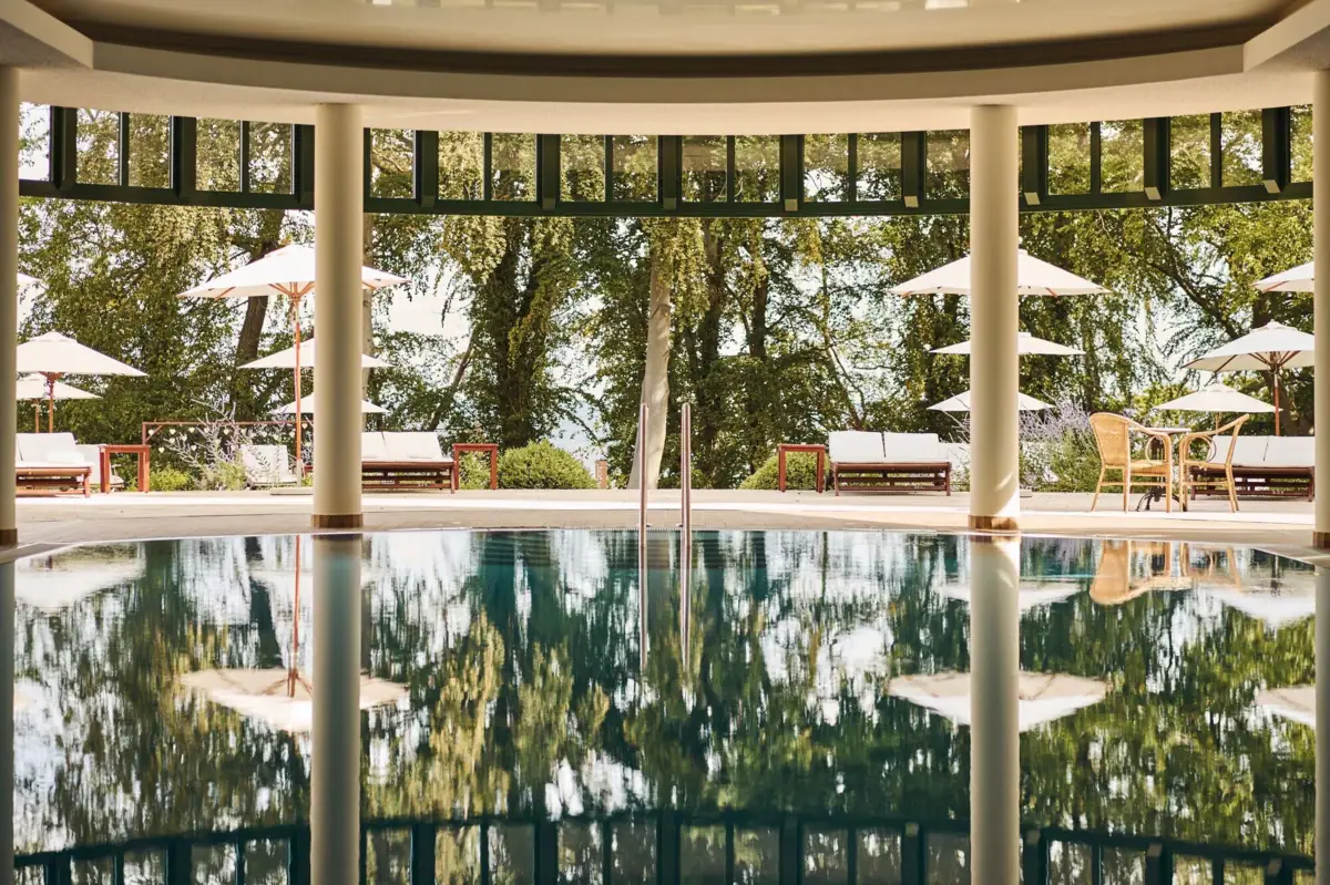 Zwembad met parasols en stoelen op de achtergrond