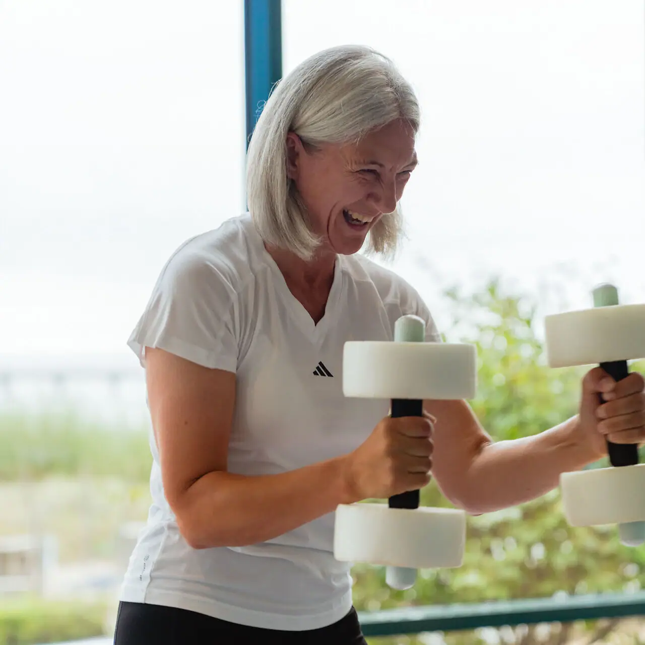 Fitness Een vrouw die gewichten heft in een sportschool.
