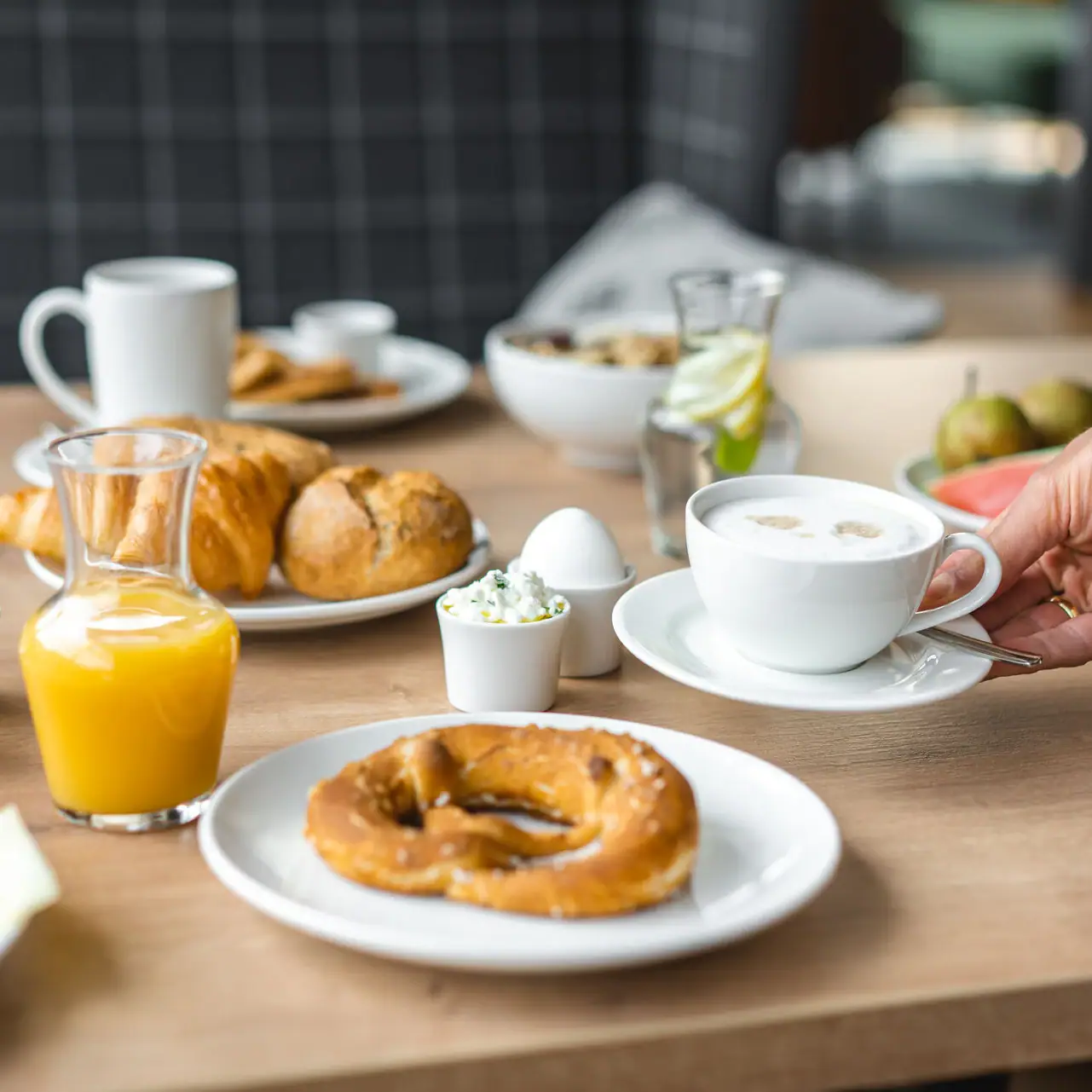 Ontbijt Een tafel met verschillende gerechten en drankjes, waaronder borden, bekers en sap.