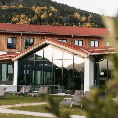 Een gebouw met een glazen wand en stoelen ervoor.