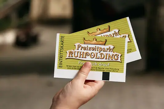 Eén hand houdt twee kaartjes vast.