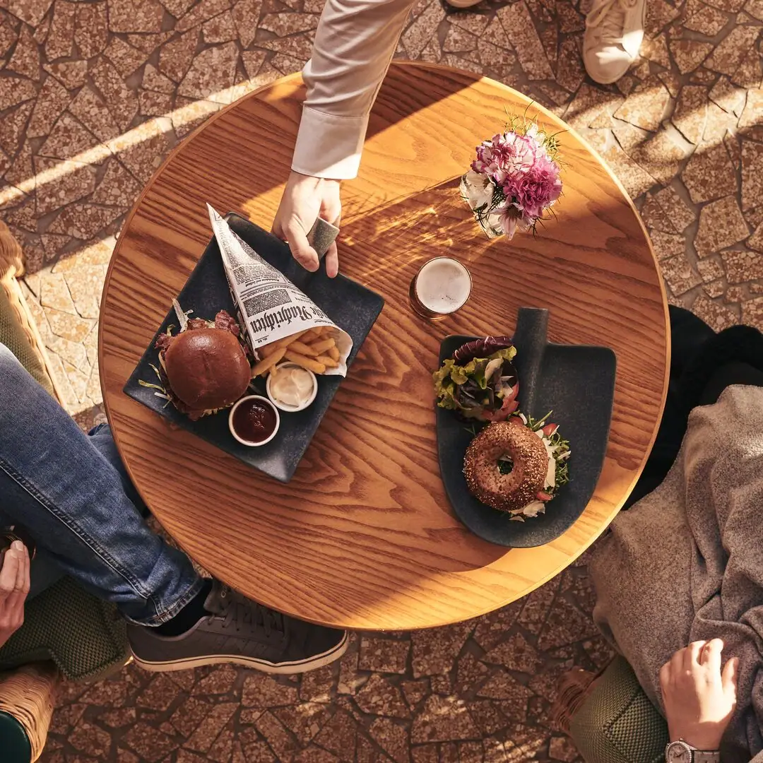Tafel met gerechten Persoon met een bord eten op tafel.