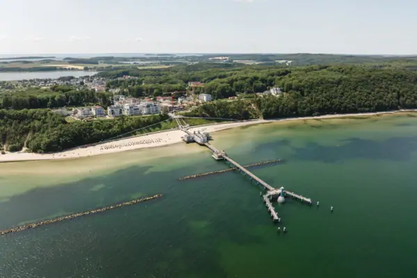 Een steiger op een strand met uitzicht op het water en de lucht.