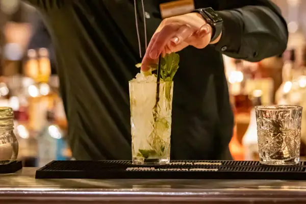 Een man houdt een tang vast aan een drankje.