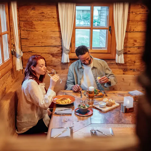 Strobl-huis Een man en een vrouw zitten aan een tafel met eten en drinken.