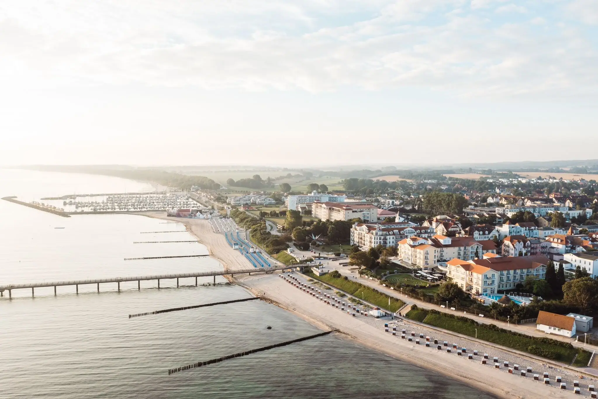 Stad naast een waterlichaam vanuit vogelperspectief met lucht en wolken.