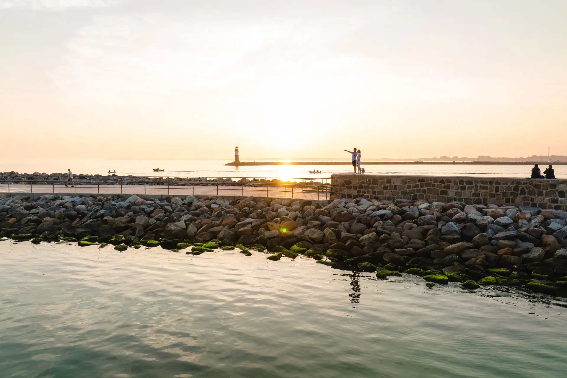 Een groep mensen staat bij het water.
