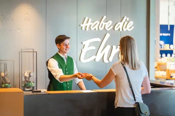 Check-in Een man overhandigt de kamerkaart aan een vrouw bij de receptie.