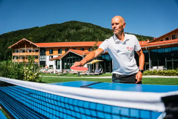 Een man houdt een tennisracket vast.