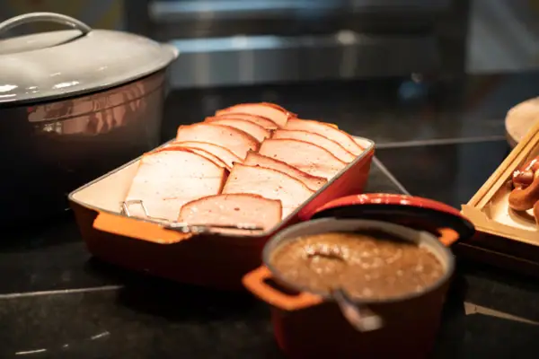 Een dienblad met gesneden vlees en een kom soep.