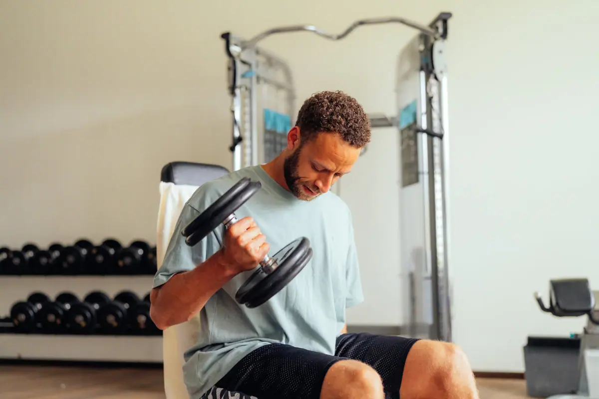 Trainen met halters Een man is aan het gewichtheffen in een sportschool.
