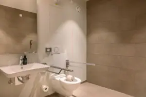 Een badkamer met toilet en wastafel.