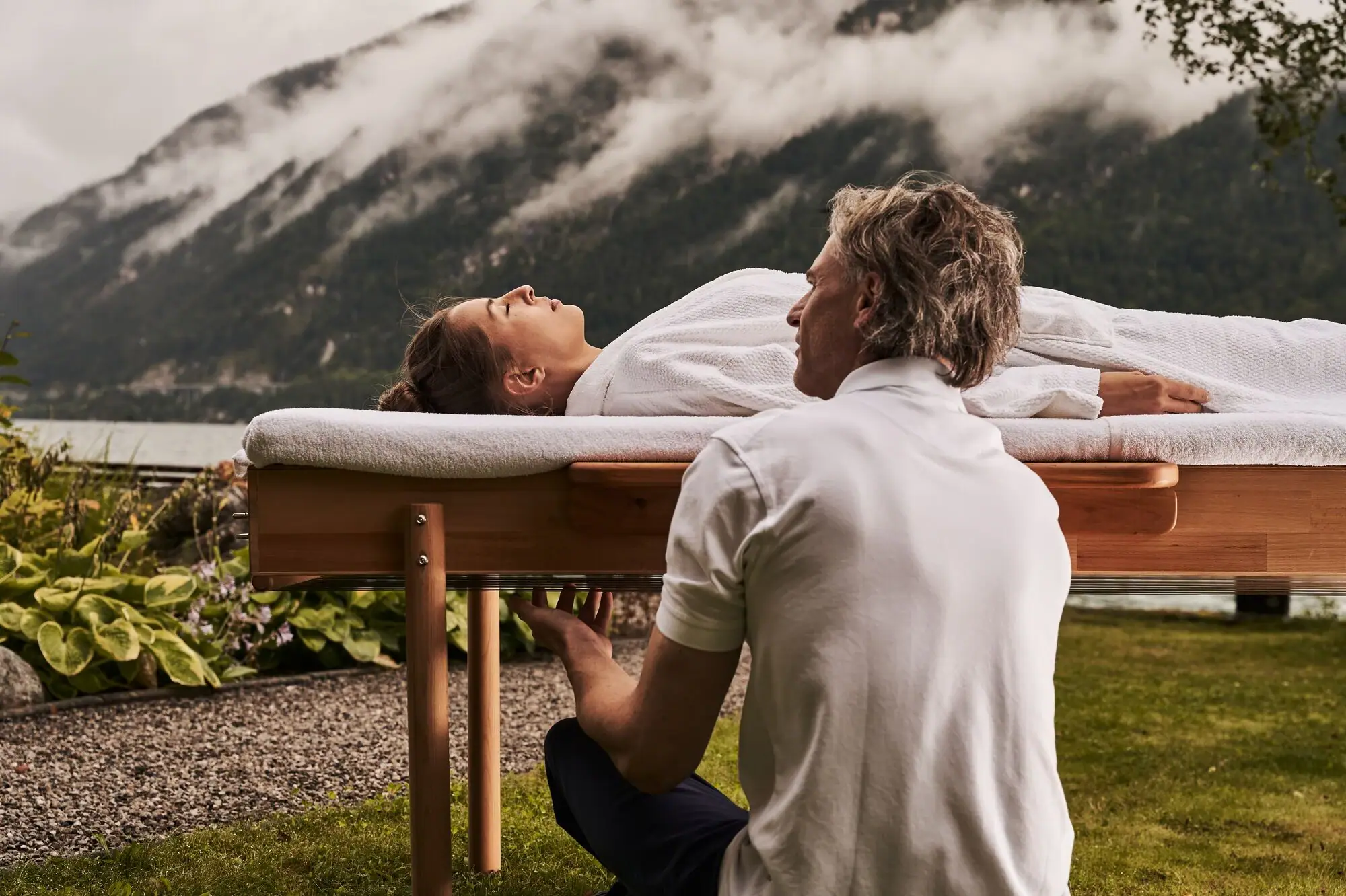 Een man knielt op een tafel waarop een vrouw ligt.
