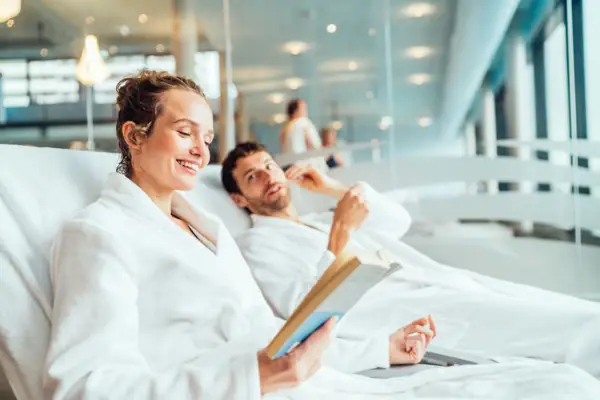Een man en een vrouw in badjassen lezen een boek.