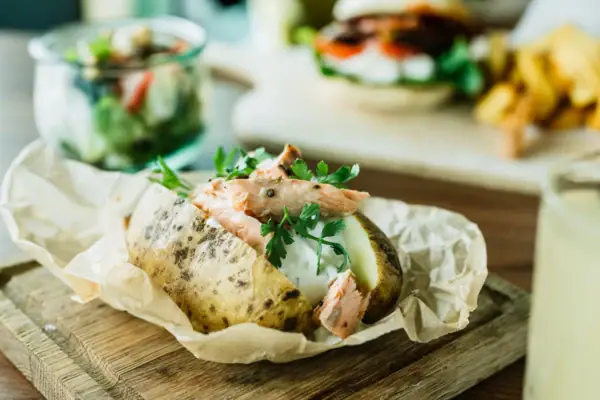 Aardappelmantel met vlees en groenten op een houten plank