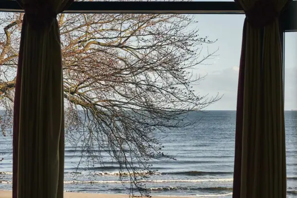 Ausblick aja Strandhotel Bansin Fenster mit Vorhängen und Blick auf den Strand