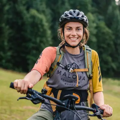 Fietsen Een vrouw rijdt op een fiets en lacht naar de camera.