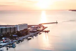Das aja Travemünde direkt am Wasser gelegen mit einem Leuchtturm im Hintergrund.