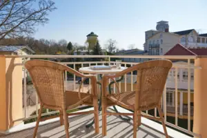 Balkon tweepersoonskamer landzijde Een tafel en stoelen op een balkon.
