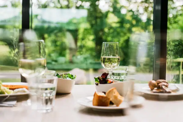 Een tafel met verschillende borden en wijnglazen.