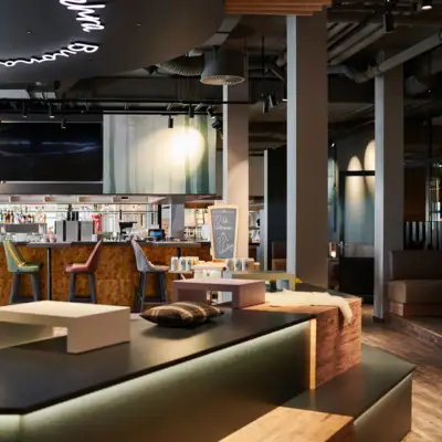 Een bar met televisie en barkrukken.