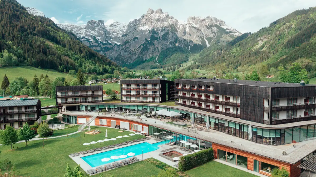 Werfenweng Mountain Resort Een hotel met een zwembad en de bergen op de achtergrond