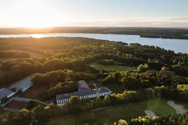 Scharmützelsee Een groot wateroppervlak met een gebouw en bomen.