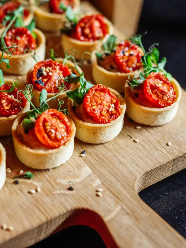 Kleine tartelettes met tomaten op een bord