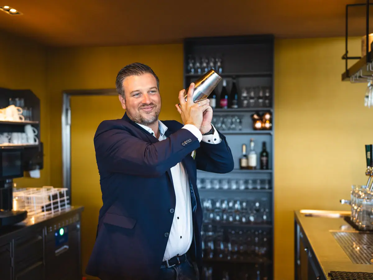 Een man houdt een shaker vast.