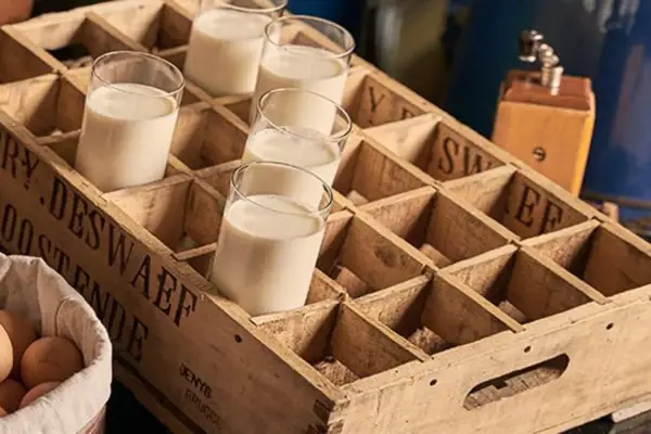 Brood en eieren in een mandje naast een glas melk