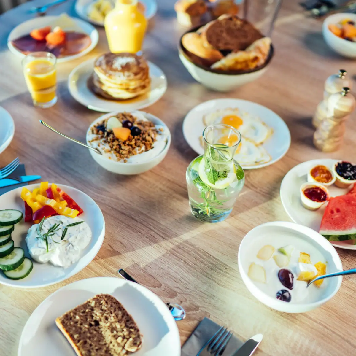 Ontbijttafel Een tafel met borden vol eten en drinken.