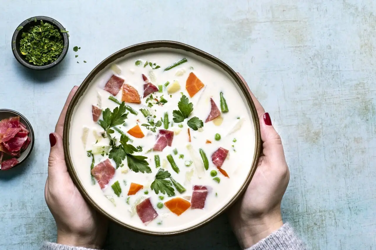 Een kom soep met groenten en vlees.