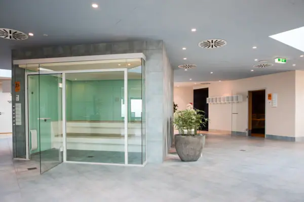 Glazen deur naar de stoomruimte met modern interieur en kamerplanten.