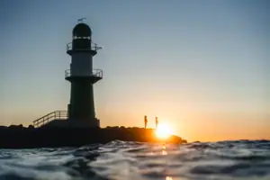 Warnemünde Leuchtturm Leuchtturm im Wasser bei Sonnenuntergang