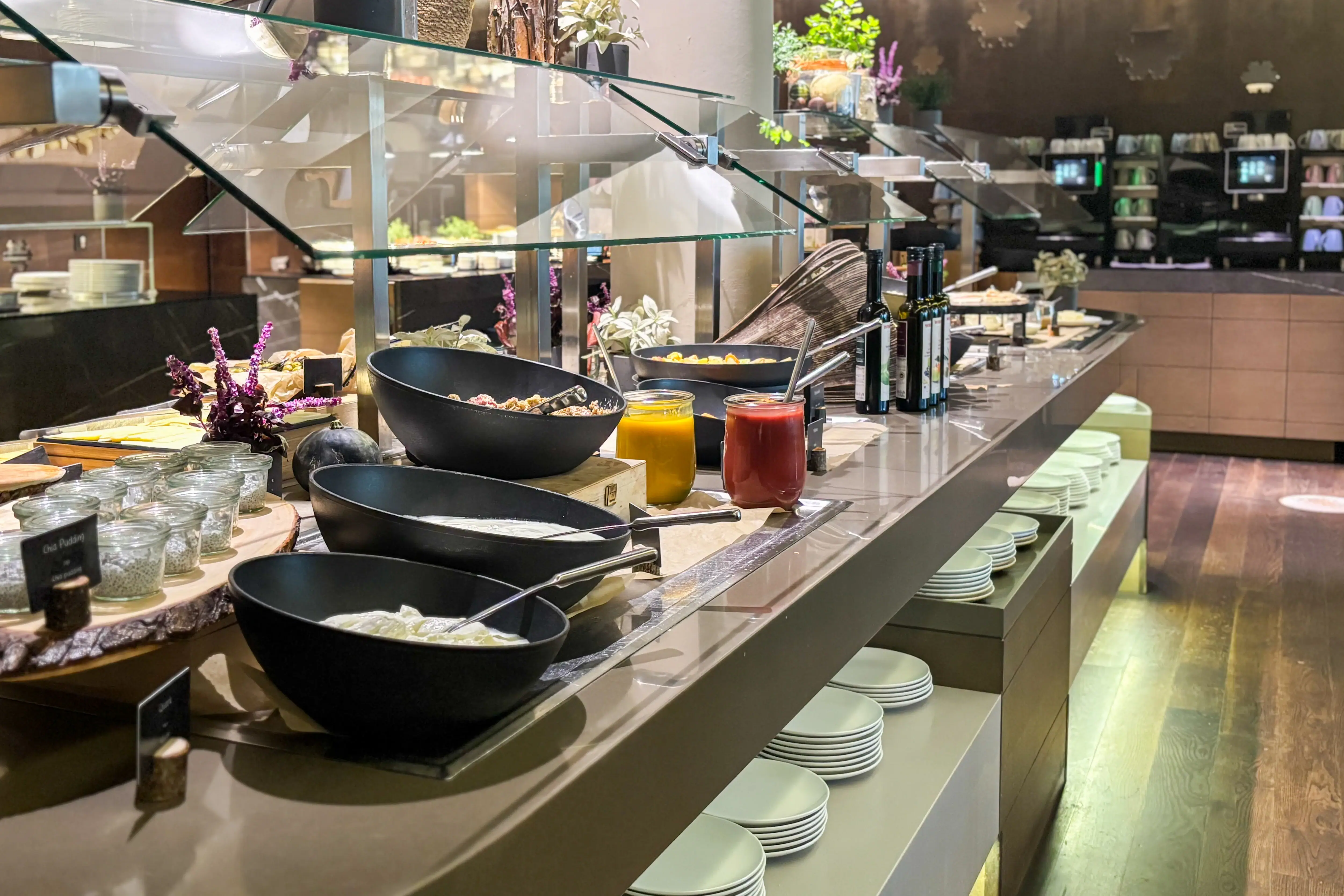 Buffettafel met borden en schalen vol eten in een restaurant.