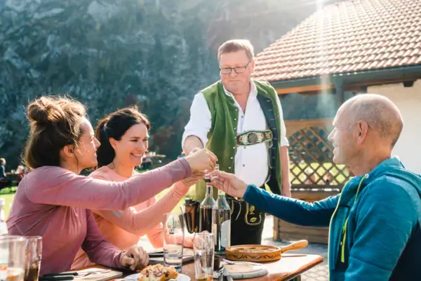 Bezoek aan de alpenweide Een groep mensen zit aan een tafel.