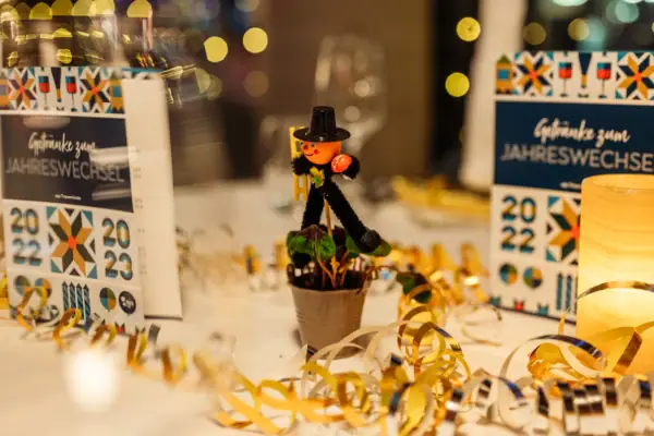 Decoratie bestaande uit een schoorsteenveger, slingers en een wit tafelkleed in het restaurant