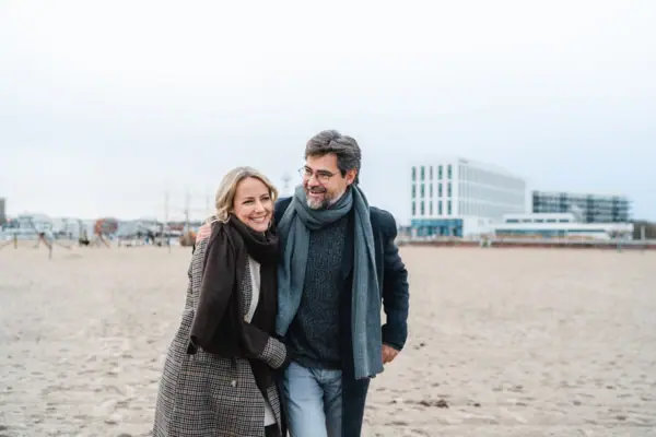 Vooruitzichten Een man en een vrouw lopen over het strand.