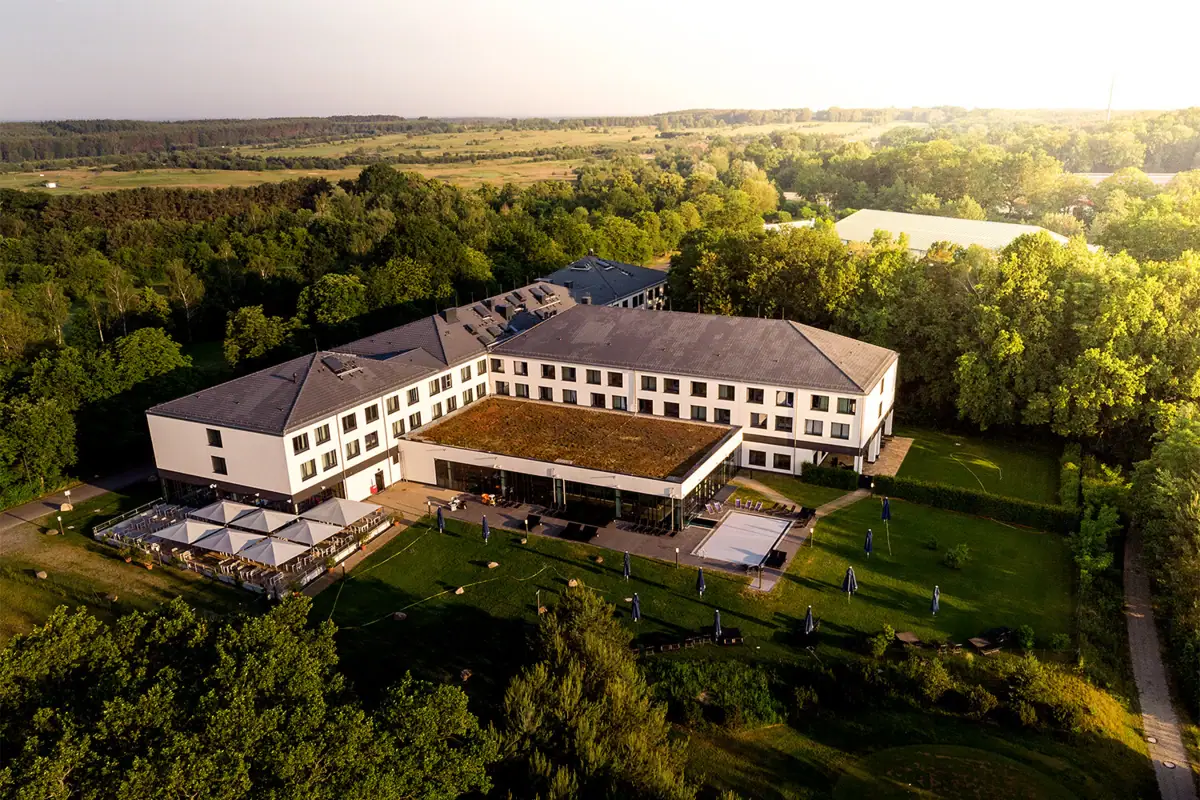 aja Bad Saarow Een groot wit gebouw met bomen op de achtergrond.
