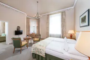 Suite Een kamer met een bed en stoelen.