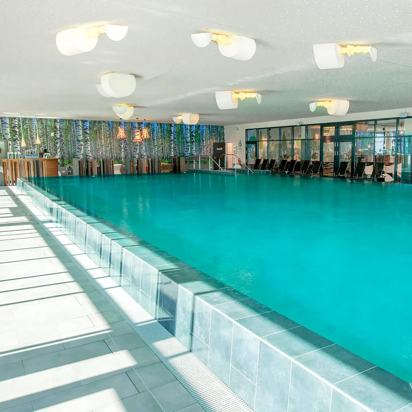 Zwembad bij aja Bad Saarow Een zwembad met stoelen en tafels.