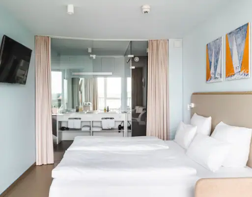 Kamers in het aja Travemünde Een kamer met een bed en een spiegel.