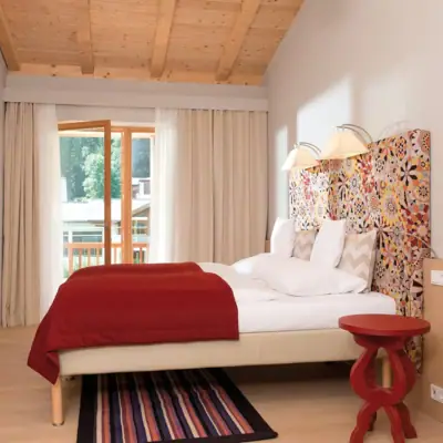 Vakantiewoning Werfenweng Een bed met een kleurrijk hoofdeinde in een kamer.