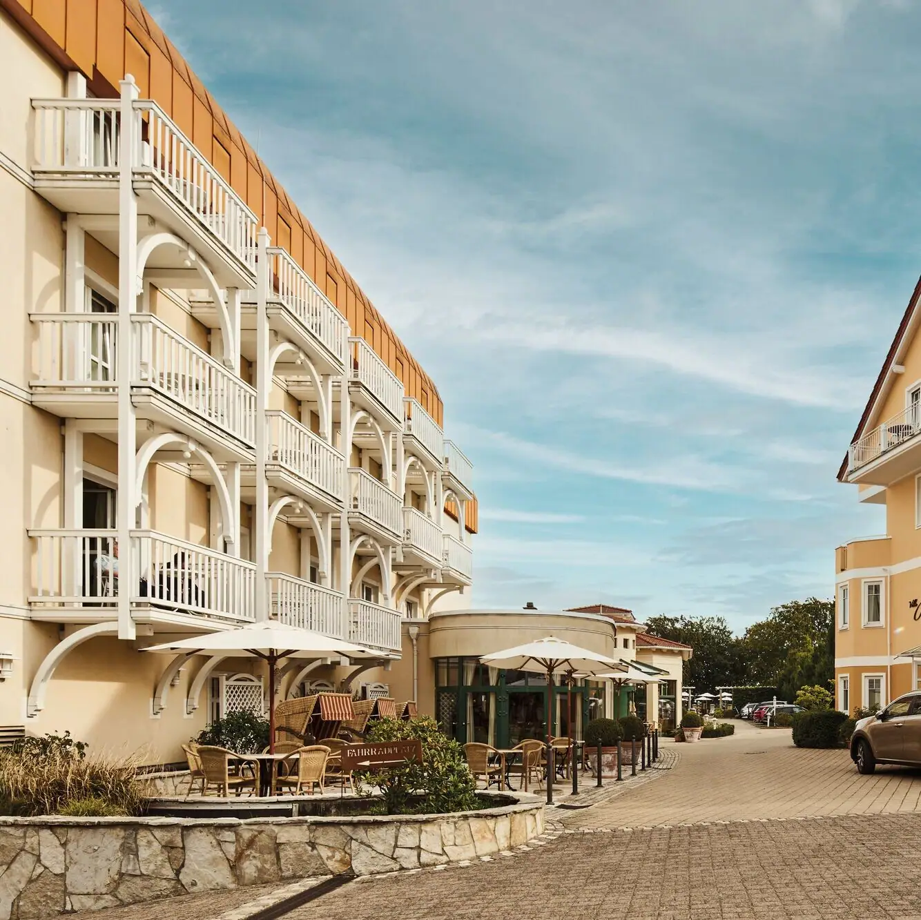 Straat met gebouwen en auto's buiten onder een bewolkte hemel.